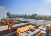 Thumbnail 7 of 33 - a roof top patio with couches and tables overlooking a city