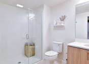 Thumbnail 29 of 33 - a white bathroom with a shower and a toilet