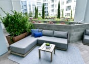 Thumbnail 25 of 33 - a patio with a couch and a coffee table and plants