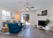 Thumbnail 2 of 27 - A living room with a blue chair and a fireplace at Nola 624 Apartments, California