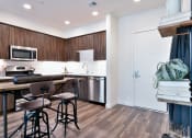 Thumbnail 24 of 33 - a kitchen with a bar and stools in front of a counter with three chairs
