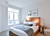Thumbnail 27 of 33 - a bedroom with a bed and a large window