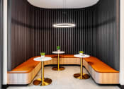 Thumbnail 16 of 30 - a lounge area with benches and tables and a lamp