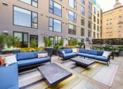Thumbnail 20 of 30 - a communal area with couches and tables in front of an apartment building