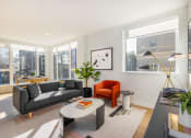 Thumbnail 1 of 30 - a living room with a couch and a coffee table and large windows