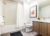 Thumbnail 6 of 30 - a bathroom with a toilet and a shower and a sink