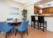Thumbnail 14 of 75 - a dining area with a table and chairs and a kitchen in the background