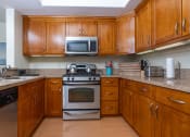 Thumbnail 16 of 75 - a kitchen with wood cabinets and stainless steel appliances