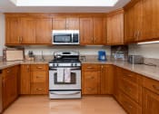 Thumbnail 23 of 75 - a kitchen with wooden cabinets and stainless steel appliances