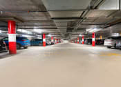 Thumbnail 49 of 75 - a parking garage with cars and red and white pillars
