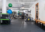 Thumbnail 39 of 75 - a gym with weights and cardio machines and a wooden table