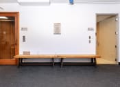 Thumbnail 63 of 75 - a wooden bench in front of a white wall with a door