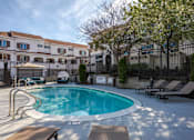 Thumbnail 5 of 46 - A pool surrounded by a fence and chairs.