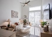Thumbnail 2 of 46 - A living room with a white sofa, a white coffee table, and a white rug.