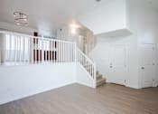 Thumbnail 22 of 46 - A white room with a staircase and two doors.