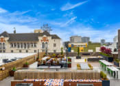 Thumbnail 22 of 30 - a rooftop terrace with tables and chairs and a city in the background
