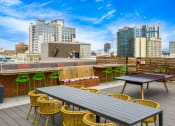 Thumbnail 23 of 30 - a rooftop patio with tables and chairs and a city in the background
