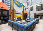 Thumbnail 21 of 30 - a patio with couches and tables in front of a building