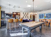 Thumbnail 16 of 98 - Apartments For Rent in 89147 Spring Valley NV - Alicante - Clubroom Featuring Pool Table, Kitchen, Modern Lighting, Bar Stools and Tables