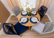 Thumbnail 36 of 98 - a dining room with a wooden table with blue chairs and a blue and white table
