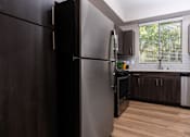 Thumbnail 47 of 98 - a kitchen with a stainless steel refrigerator and a window