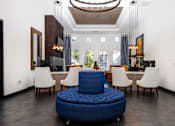 Thumbnail 29 of 98 - a living room with a blue chair and a table with chairs