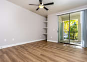 Thumbnail 82 of 98 - an empty living room with a ceiling fan and a sliding glass door