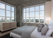 Thumbnail 25 of 29 - One-Bedroom Apartments in Oakland, CA - Aqua Via - Furnished Bedroom with 2 Large Windows, Plush Carpeting, and Stylish Decor at Aqua Via Apartments, Oakland, CA