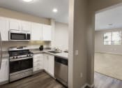 Thumbnail 6 of 25 - a kitchen with white cabinets and stainless steel appliances at 55+ Remington at Ladera Ranch, California