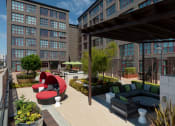 Thumbnail 11 of 29 - a rendering of a rooftop patio with couches and chairs at Aqua Via Apartments, Oakland, CA