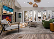 Thumbnail 32 of 57 - A living room with a fireplace and a painting of a beach scene on the wall.