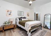 Thumbnail 11 of 57 - A bedroom with a bed, a nightstand, and a ceiling fan.
