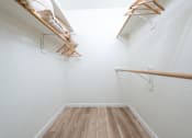 Thumbnail 26 of 57 - A hallway with a white wall and a wooden floor.