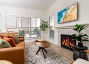 Thumbnail 8 of 57 - A living room with a fireplace and a painting on the wall.