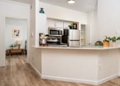 Thumbnail 10 of 57 - A kitchen with a white counter and a fridge.