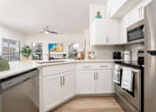 Thumbnail 9 of 57 - A modern kitchen with white cabinets and stainless steel appliances.