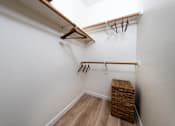 Thumbnail 17 of 57 - A white wall with a wooden hanger and a brown wicker basket.