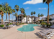 Thumbnail 3 of 57 - A pool surrounded by palm trees and sun loungers.