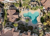 Thumbnail 4 of 57 - A bird's eye view of a residential area with a large swimming pool in the center.
