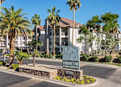 Thumbnail 5 of 57 - A sign for Arboretum Apartments is in front of a building with palm trees.