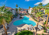 Thumbnail 1 of 57 - A pool surrounded by palm trees and chairs.