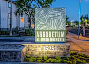 Thumbnail 53 of 57 - A sign for Arboretum at South Mountain stands in front of a building.