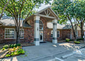 Thumbnail 1 of 29 - A brick building with a white door and pillars.