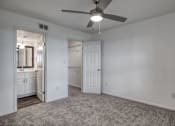 Thumbnail 10 of 29 - A room with a ceiling fan and carpeted floor.