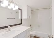 Thumbnail 12 of 29 - A white bathroom with a sink, toilet, and bathtub.