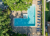 Thumbnail 19 of 29 - An aerial view of a swimming pool surrounded by trees and lounge chairs.