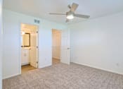 Thumbnail 14 of 29 - A room with a ceiling fan and carpeted floor.