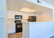 Thumbnail 15 of 29 - A kitchen with black appliances and white cabinets.