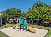 Thumbnail 25 of 29 - A playground with a slide, swings, and a sandbox.