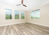 Thumbnail 25 of 60 - bedroom with windows and ceiling fam and wood style flooring.